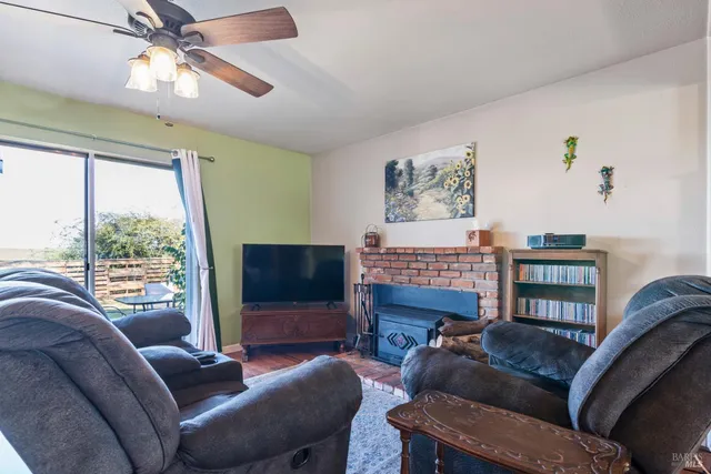 a living room with furniture a window and a flat screen tv