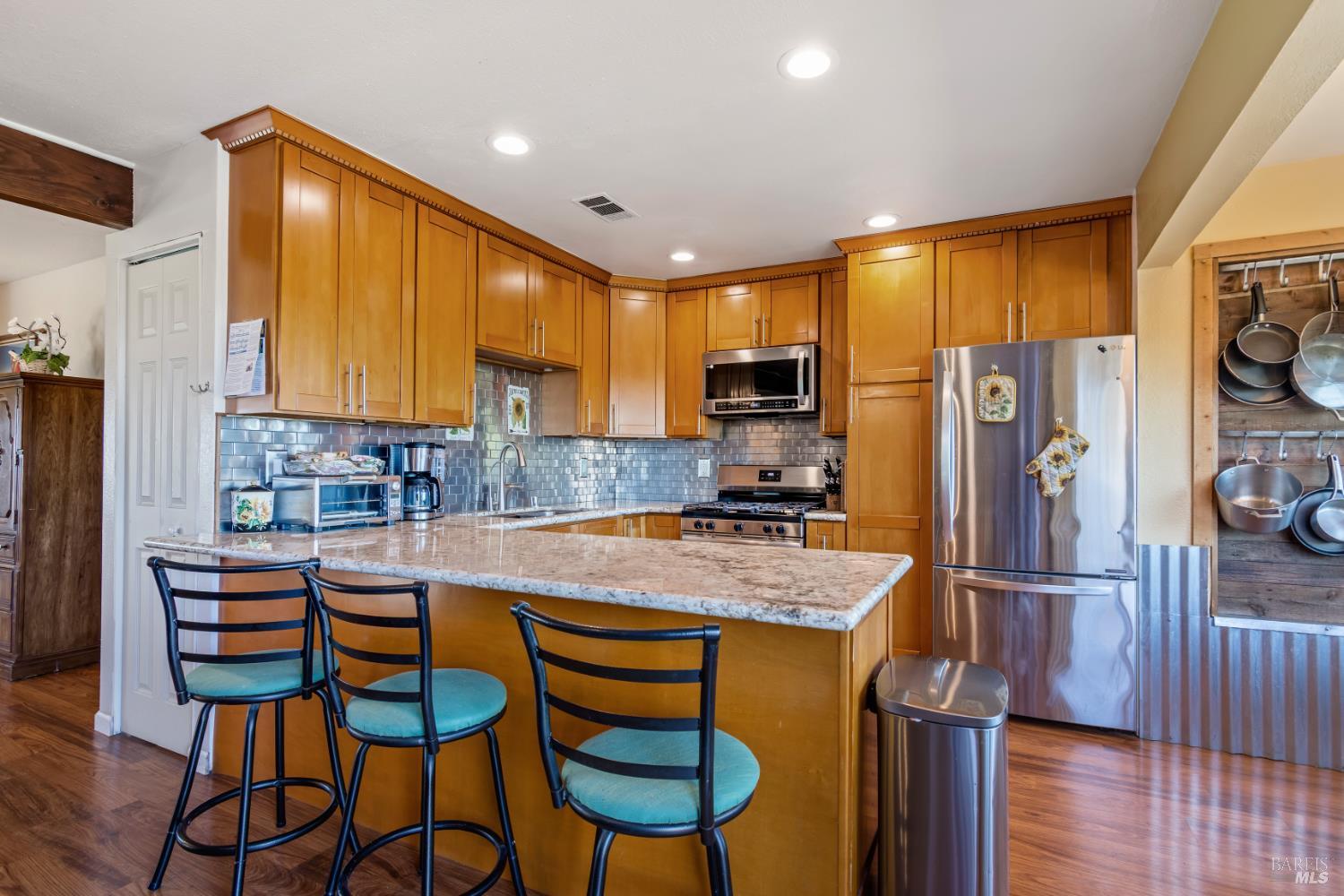17 Amador Circle Rio Vista, CA 94571 - Photo 15 of 42 a kitchen with stainless steel appliances granite countertop a refrigerator a sink dishwasher a stove a dining table and chairs with wooden floor