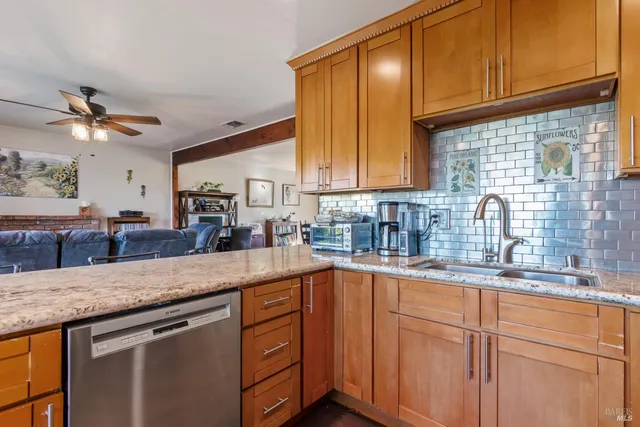 a kitchen with stainless steel appliances granite countertop a sink a stove and cabinets