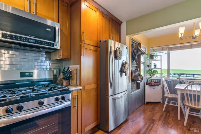 a kitchen with a stove a refrigerator and a stove top oven