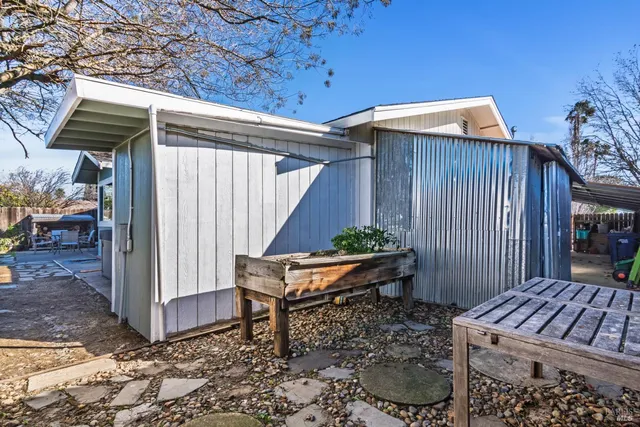 a backyard of a house with barbeque oven table and chairs