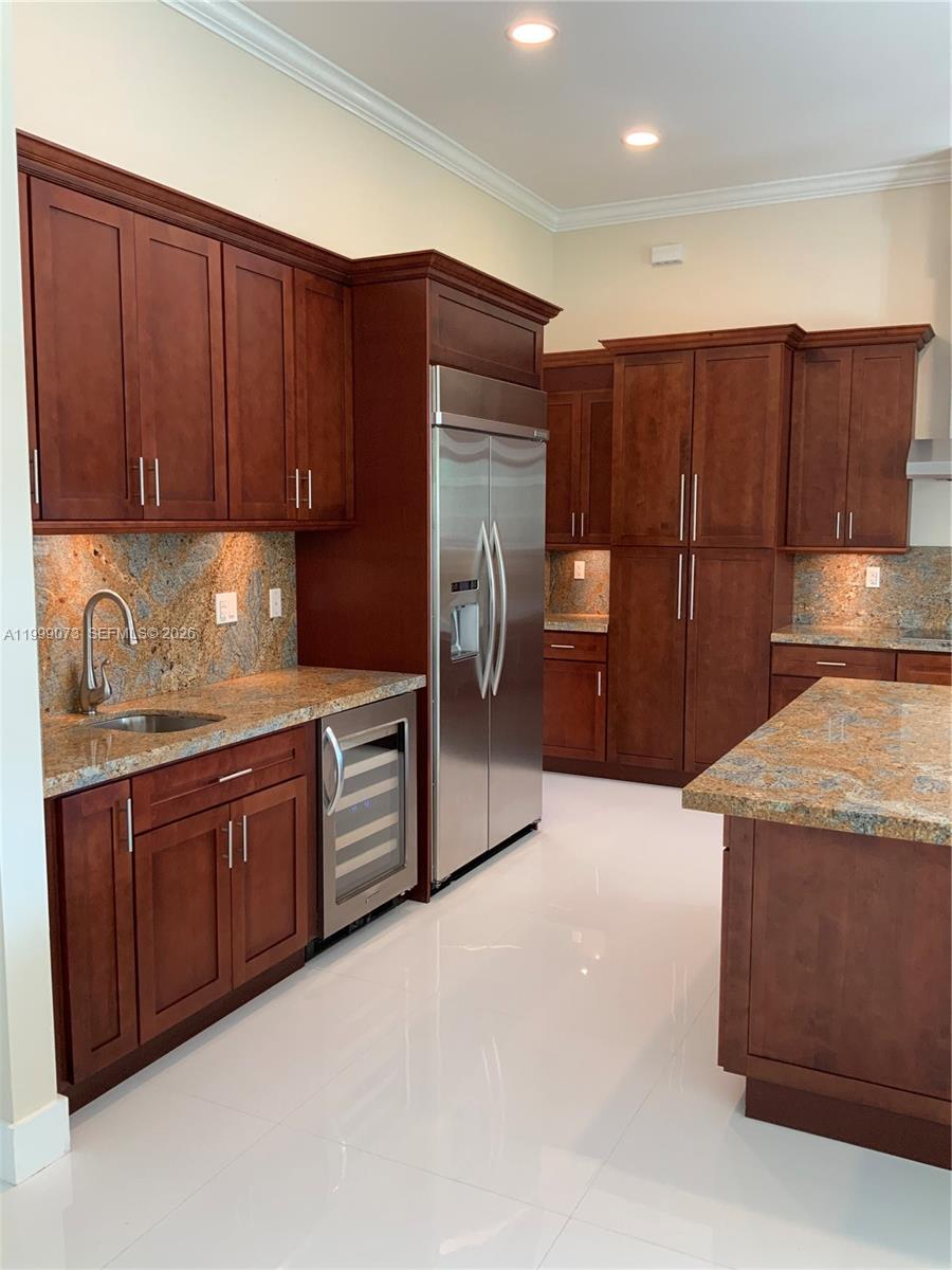 12308 Southwest 94th Place Miami, FL 33176 - Photo 10 of 21 a kitchen with stainless steel appliances granite countertop wooden cabinets a refrigerator and a sink