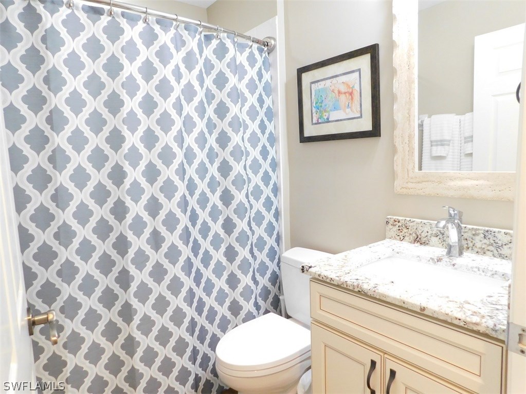 2090 Matecumbe Key Road, Unit 1307 Punta Gorda, FL 33955 - Photo 13 of 25 a bathroom with a granite countertop toilet and a sink