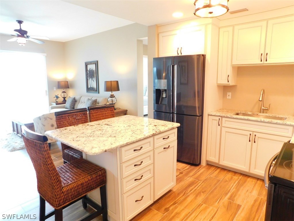 2090 Matecumbe Key Road, Unit 1307 Punta Gorda, FL 33955 - Photo 5 of 25 a kitchen with stainless steel appliances kitchen island granite countertop a table chairs and a refrigerator