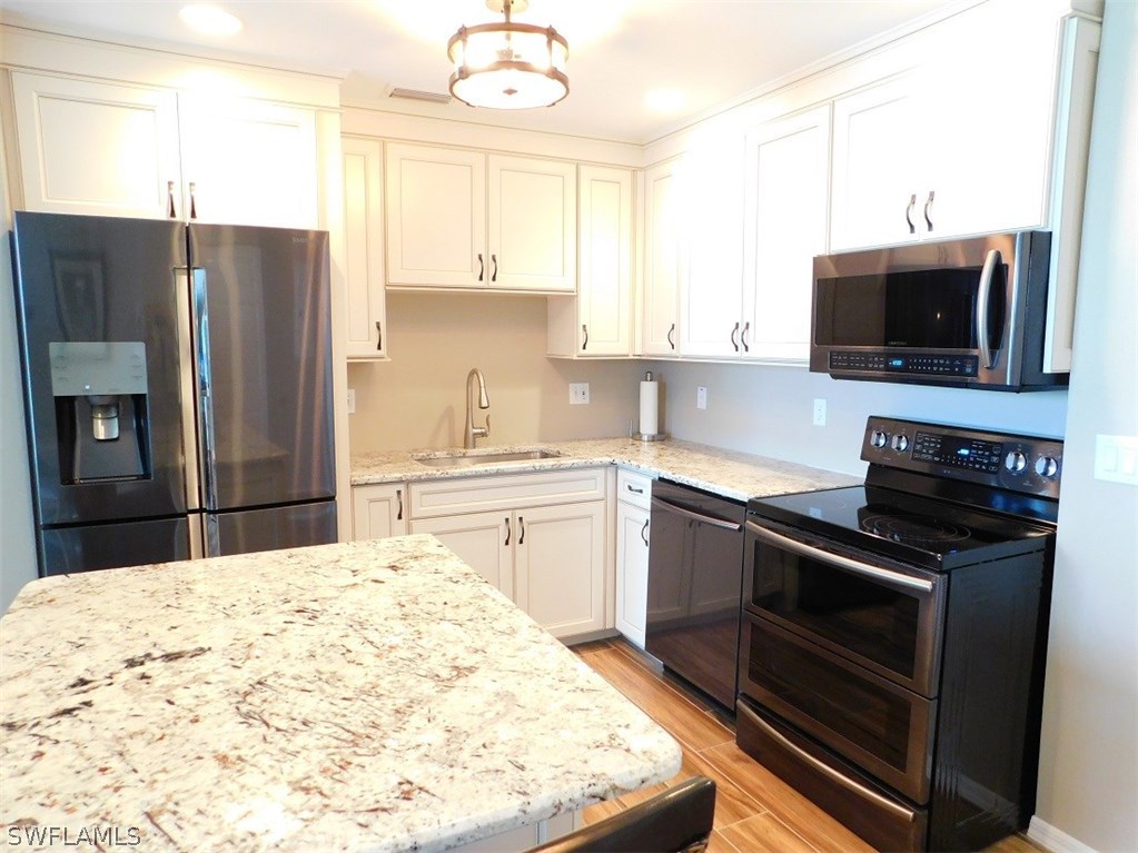 2090 Matecumbe Key Road, Unit 1307 Punta Gorda, FL 33955 - Photo 6 of 25 a kitchen with a stove a sink and a refrigerator