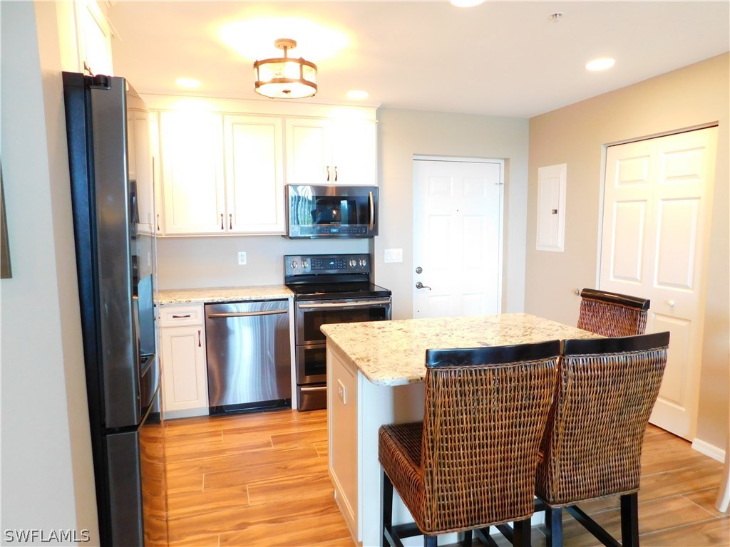 2090 Matecumbe Key Road, Unit 1307 Punta Gorda, FL 33955 - Photo 7 of 25 a kitchen with stainless steel appliances kitchen island granite countertop a sink and a refrigerator
