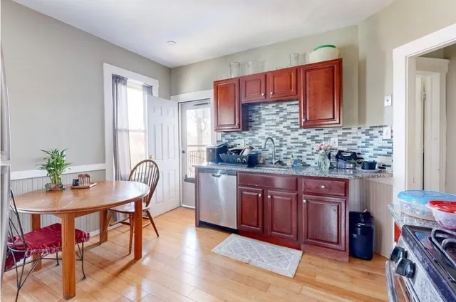 a kitchen with granite countertop a table and chairs in it