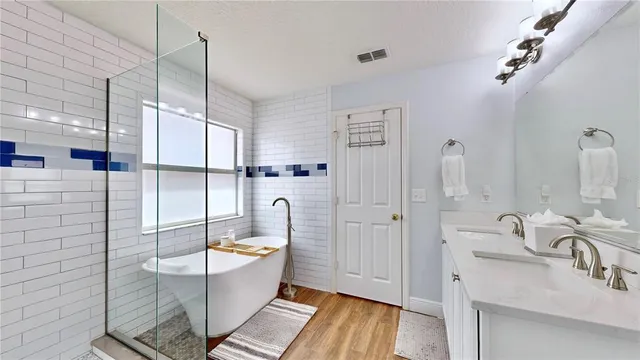 a bathroom with a tub sink shower and mirror