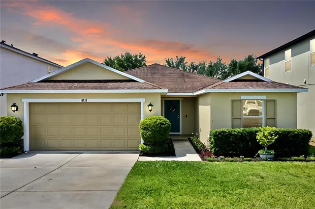 a front view of a house with a yard and garage