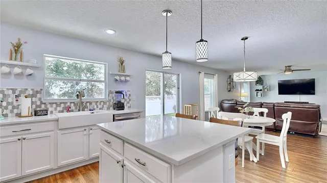 a kitchen with stainless steel appliances granite countertop a sink a microwave oven and a dining table with wooden floor