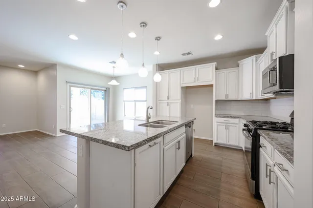 a kitchen with stainless steel appliances granite countertop a sink stove and refrigerator