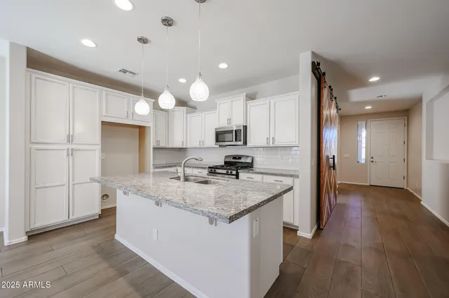 a kitchen with a refrigerator sink and cabinets