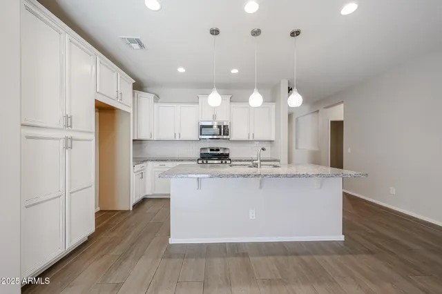 a kitchen with kitchen island a sink stainless steel appliances and cabinets