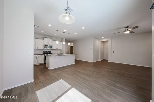 a view of kitchen with kitchen island stainless steel appliances sink and cabinets