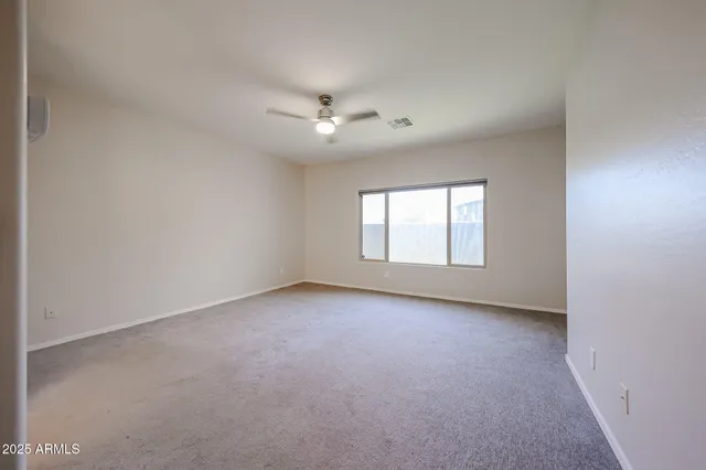 an empty room with a ceiling fan and a window
