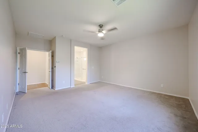 an empty room with fan and a ceiling fan