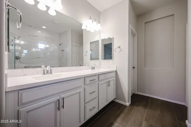 a spacious bathroom with a double vanity sink and mirror