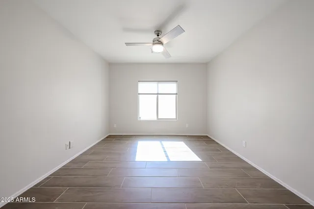 an empty room with windows and fan