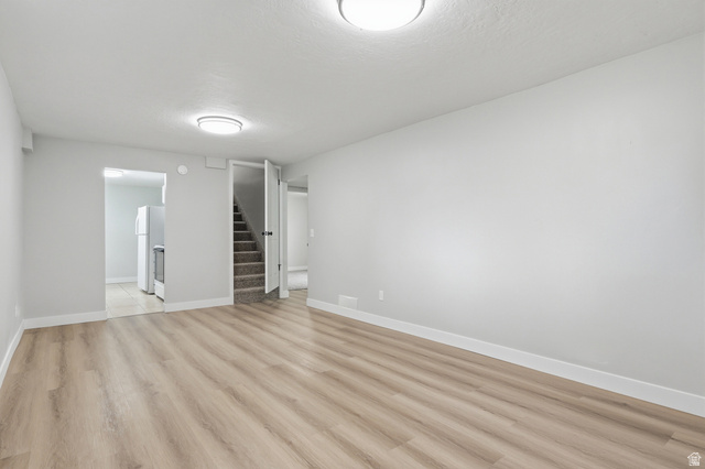 629 King Circle Layton, UT 84041 - Photo 16 of 26 Spacious room featuring wood-finish flooring, light grey wall paint, and white baseboards
