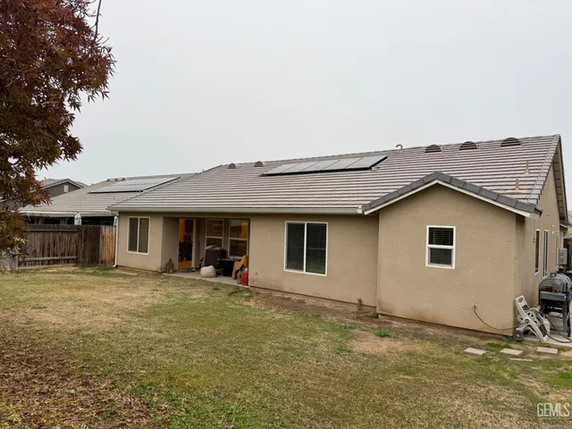 a view of a big house with a big yard and large trees
