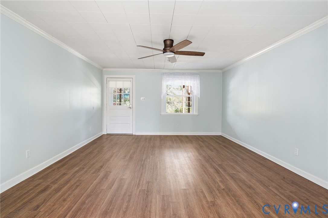 9102 Boydton Plank Road Petersburg, VA 23803 - Photo 17 of 32 an empty room with wooden floor chandelier fan and windows