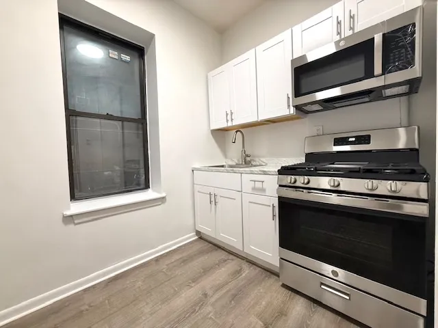 a kitchen with white cabinets and white appliances
