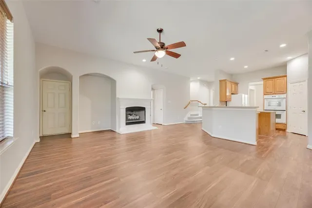 a view of a kitchen with furniture a ceiling fan and wooden floor