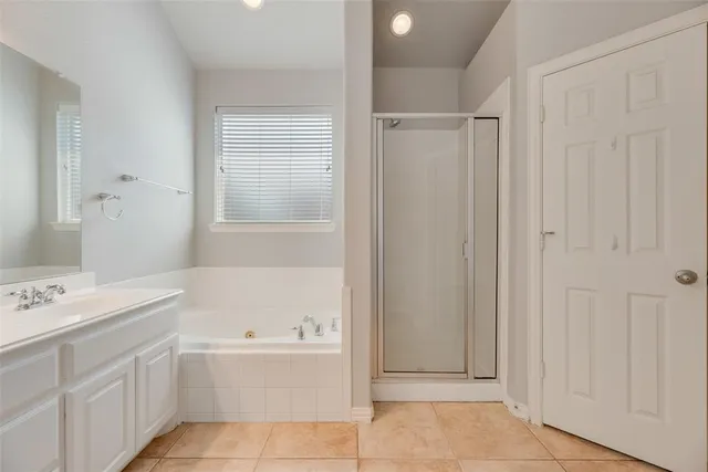 a bathroom with a bathtub a sink a vanity and a window