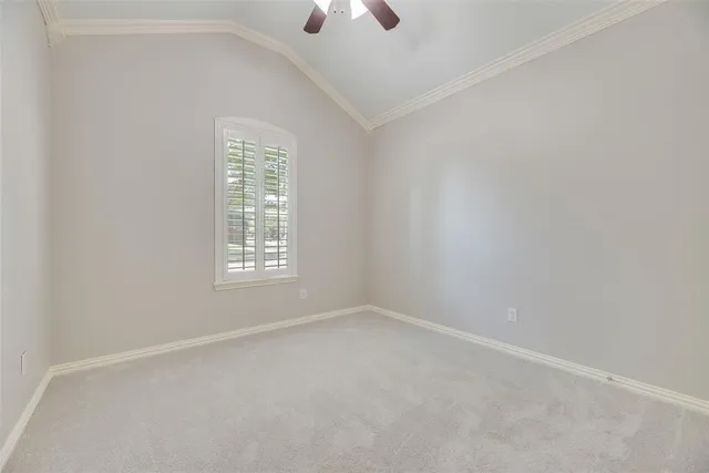 an empty room with a window and a ceiling fan