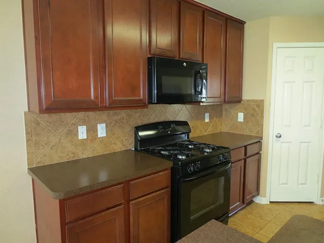 a kitchen with stainless steel appliances granite countertop a stove a sink and a microwave