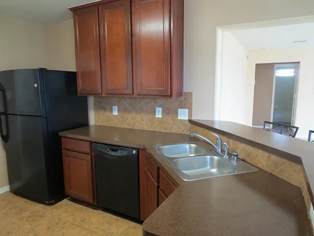 a kitchen with a sink refrigerator and cabinets