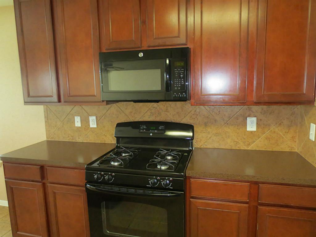 22303 Bridgestone Ridge Drive Spring, TX 77389 - Photo 8 of 25 a kitchen with a stove and a microwave