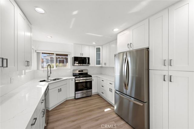 a kitchen with stainless steel appliances a refrigerator stove microwave and sink
