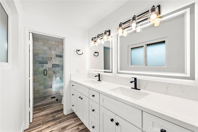 a bathroom with a double vanity sink mirror and shower