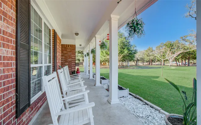 a view of a porch with a table and chairs and potted plants