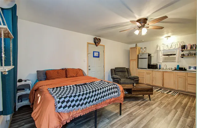 a bedroom with a bed and wooden floor