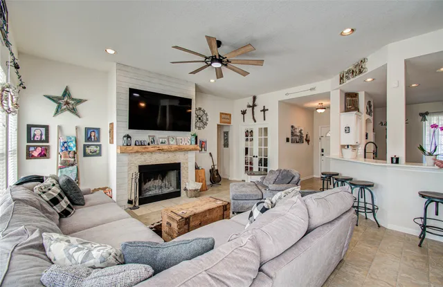 a living room with furniture a flat screen tv and a fireplace
