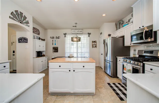 a large kitchen with stainless steel appliances granite countertop a lot of counter space and wooden floor