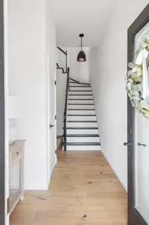 a view of a hallway with wooden floor and staircase