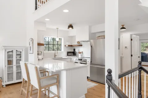 a kitchen with stainless steel appliances granite countertop a refrigerator and a stove top oven