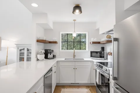 a kitchen that has a lot of cabinets and a wooden floor