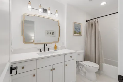 a bathroom with a sink a toilet and mirror