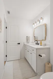 a bathroom with a double vanity sink mirror and toilet
