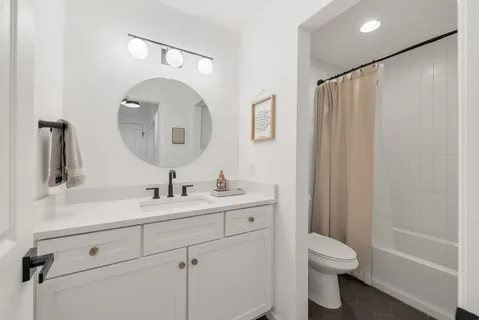a bathroom with a toilet sink and mirror