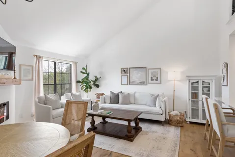 a living room with furniture a large window and a flat screen tv