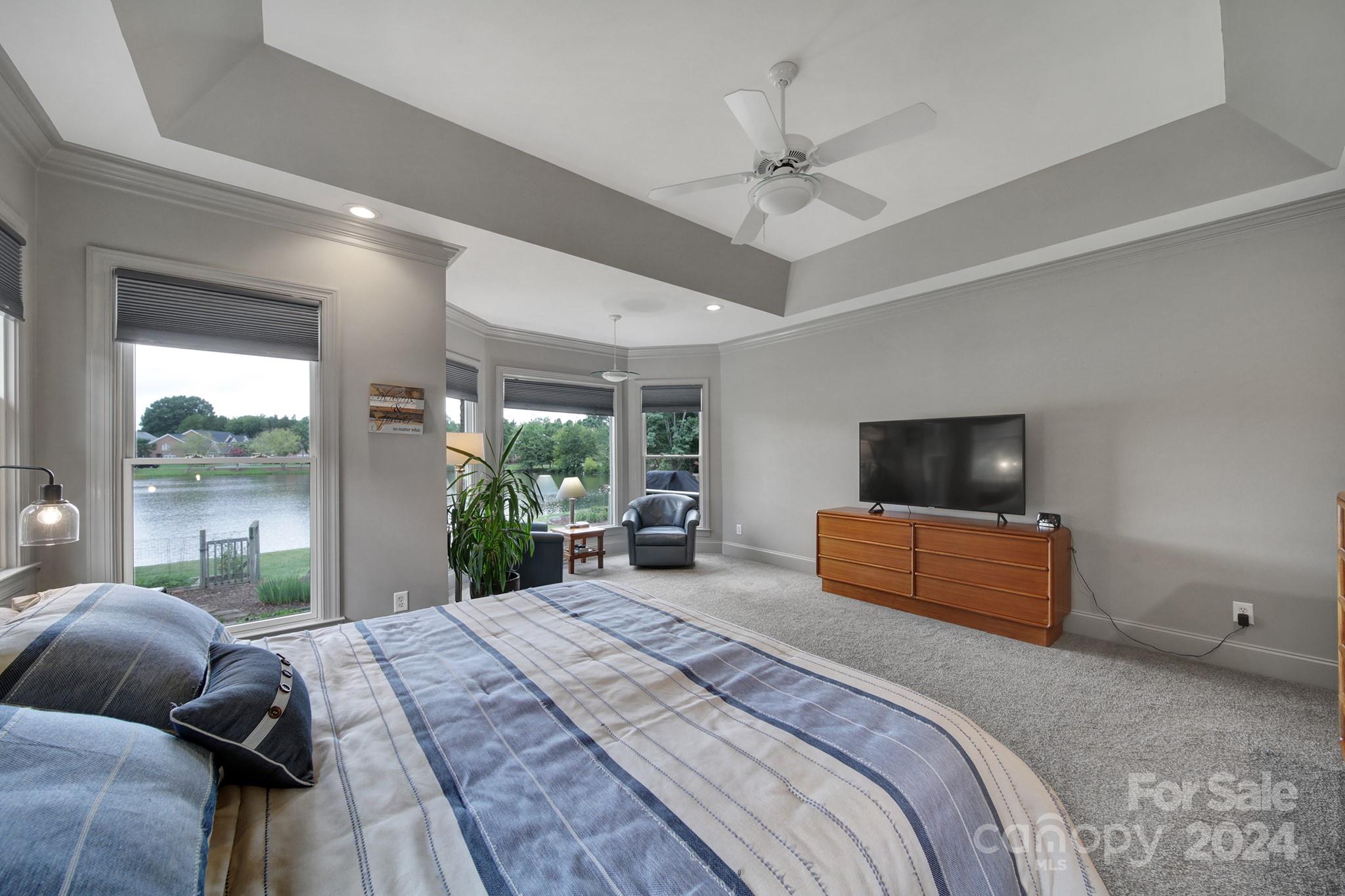 216 Edgewater Way Fort Mill, SC 29708 - Photo 20 of 45 a bedroom with a large bed a flat screen tv and a couch