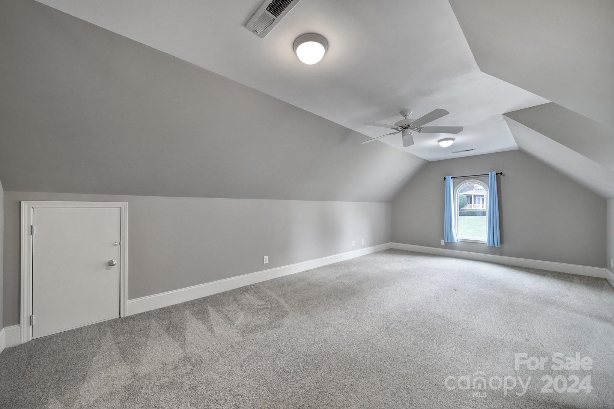 216 Edgewater Way Fort Mill, SC 29708 - Photo 29 of 45 an empty room with a chandelier fan and windows