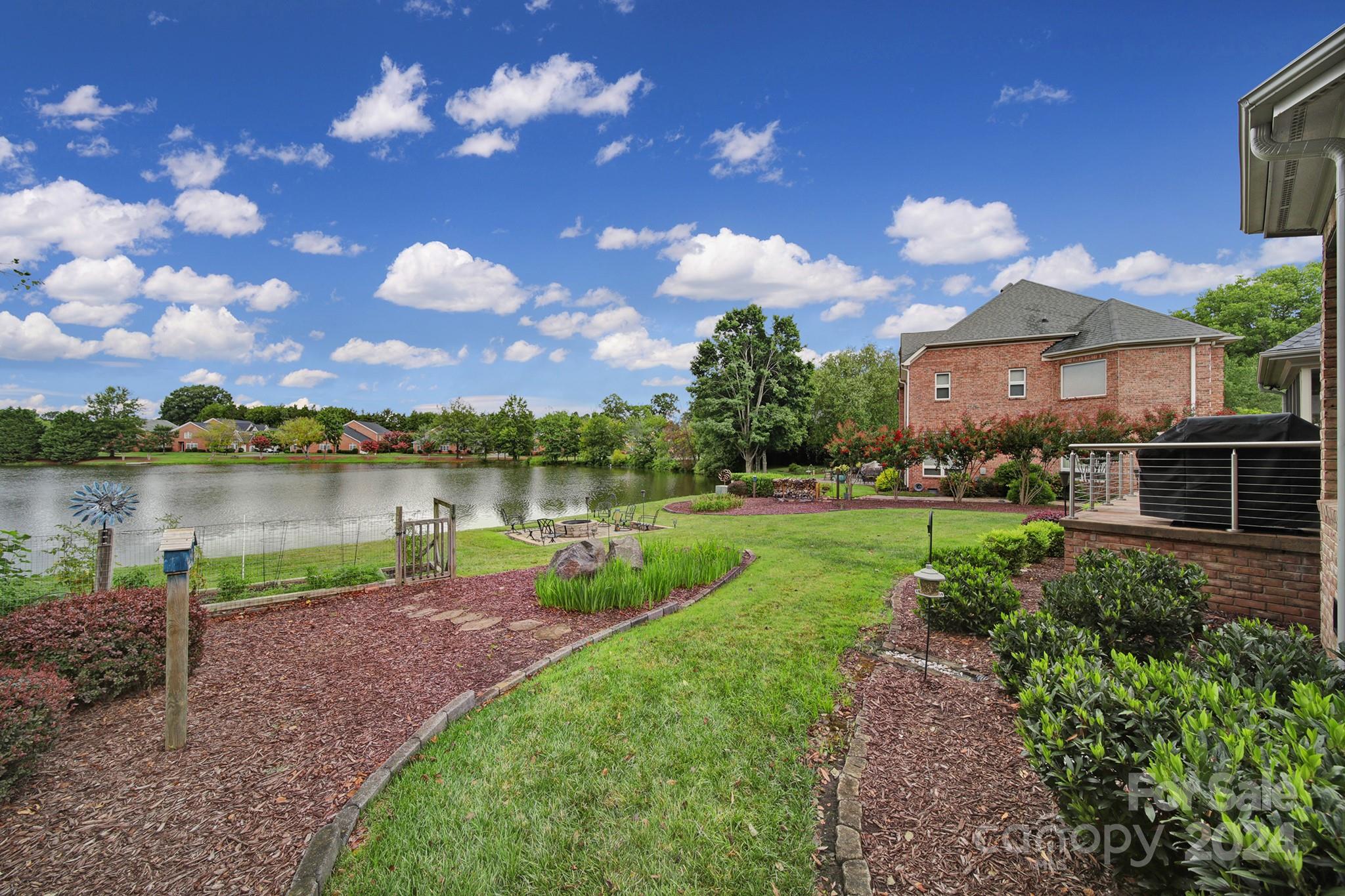 216 Edgewater Way Fort Mill, SC 29708 - Photo 43 of 45 a view of a lake with a house in the background