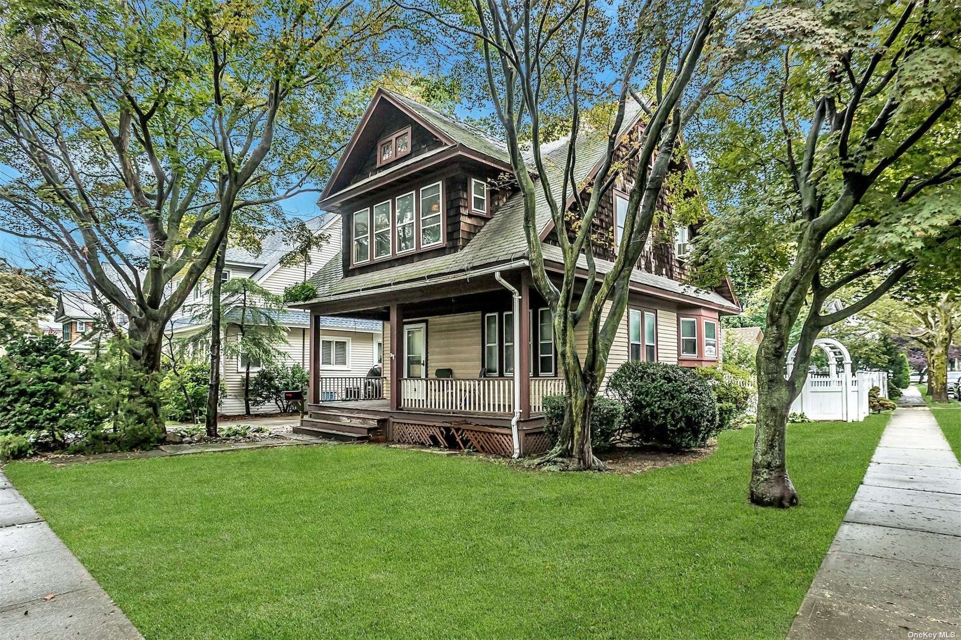 266 Earle Avenue Lynbrook, NY 11563 - Photo 1 of 21 a view of a house with a big yard and large trees