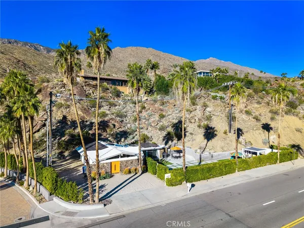an aerial view of a house with a yard and large trees
